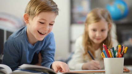 Happy child boy reading book for his little sister which draws with colorful pencils - Powered by Adobe