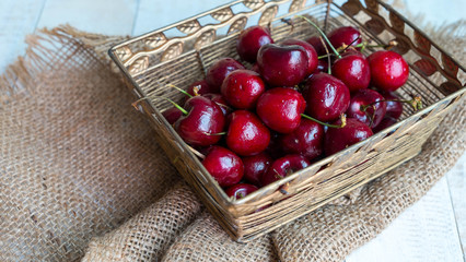 Cherries in gold basket on hemp