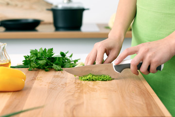 Close up of  woman's hands cooking in the kitchen. Housewife slicing ​​fresh salad. Vegetarian and healthily cooking concept