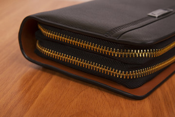 wallet closed by two zippers closeup on wooden background