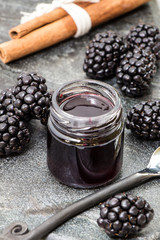 Homemade blackberry jam with cinnamon stick and rustic spoon