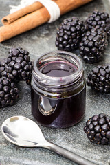 Homemade blackberry jam with cinnamon stick and rustic spoon