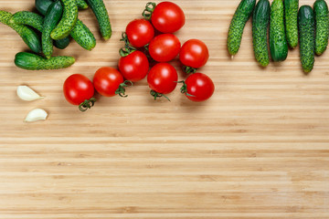 Set of Cucumbers, tomatoes cherry and garlic on the wooden table. Top view.