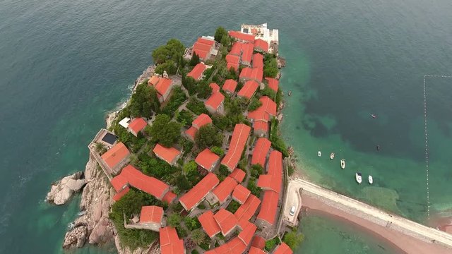 Narrow isthmus connecting mainland with Sveti Stefan islet. Aerial view at the beaches, island and seaside. Aman Sveti Stefan hotel with the Villa Milocer, Montenegro
