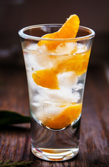 Glass with fresh juicy ripe Mandarins Tangerines, ice. Copy space and Closeup on dark background. Front view