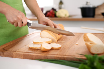 Close up of  woman's hands cooking in the kitchen. Housewife slicing ​​white bread. Vegetarian and healthily cooking concept