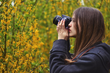 Girl taking photo of blossoming tree