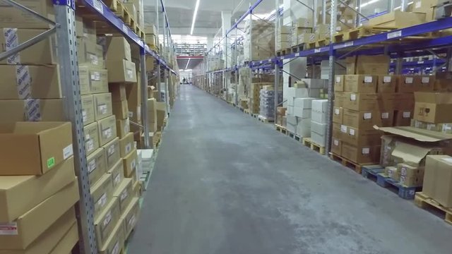 View of shelves with cardboard boxes in storage warehouse HD video. Logistics stock indoor interior