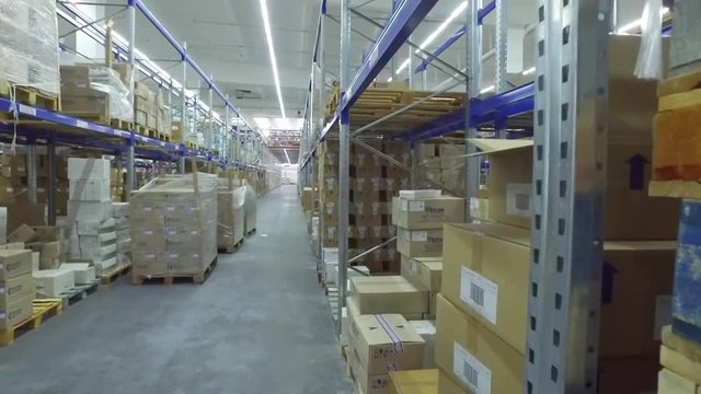View of shelves with cardboard boxes in storage warehouse HD video. Logistics stock indoor interior
