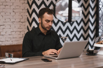 Successful freelancer working on laptop computer in modern inter