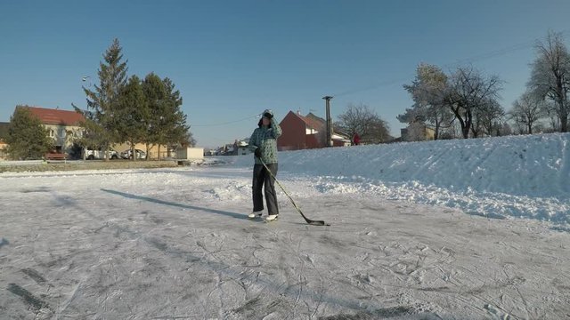 Little boy playing hockey. The child learns to skate and shoot with a stick.
