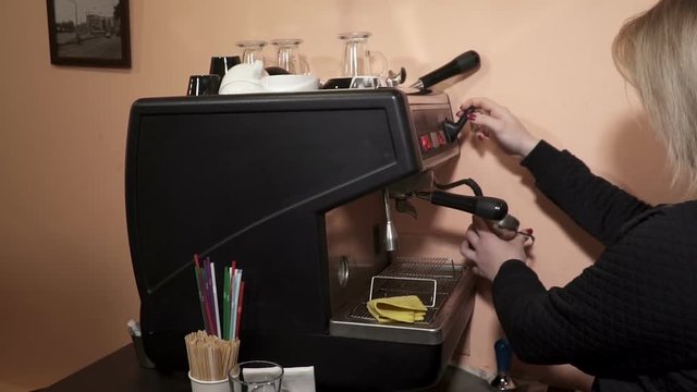 young woman uses coffee mahine in cafee, slow motion