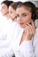 Call center. Focus on beautiful woman in headset