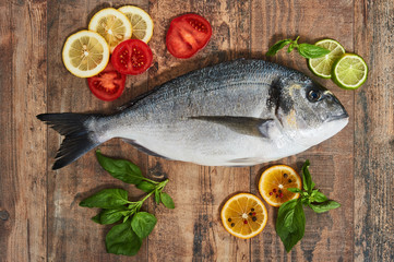 Raw uncooked dorado on wooden table.