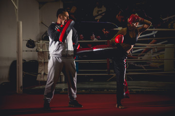Kick boxer hitting mitts held by training partner