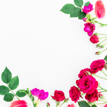 Wreath frame made of flowers, green leaves, branches on white background. Flat lay, top view. Valentine's background