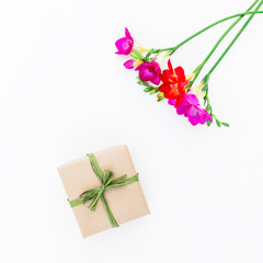 Freesia flowers and gift box isolated on white background. Flat lay, top view. Valentines Day background.