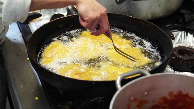 A female cook frying some chicken cutlets in the oil in Italy, 4K