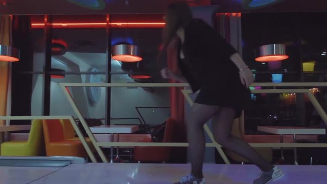 Woman chooses bowling ball and rolling to alley HD leisure video. Friends playing hobby game. Girl doing throw