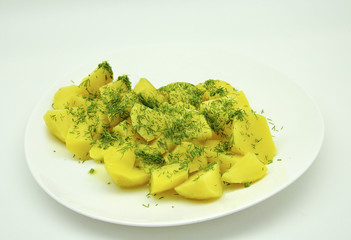 boiled potatoes with dill on a white plate on a white background