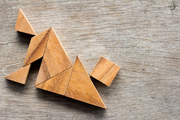 Wooden tangram puzzle in man lay down shape background
