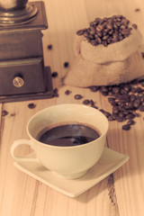 Coffee cup and coffee beans on wood table