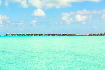Stunning view of blue turquoise lagoon and far bungalows on back
