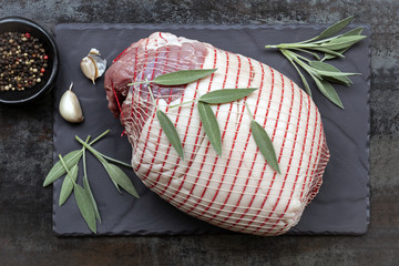 Raw Pork Roast Top View on Slate with Sage and Spices