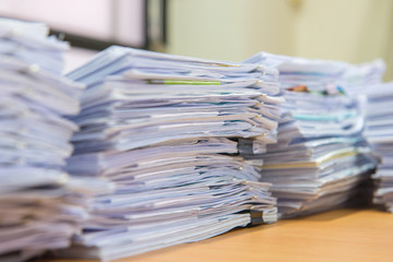 documents on desk stack up high waiting to be managed