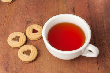 Tea cup and butter cookies with heart-shaped filling