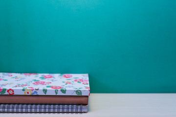 Books stacked on wooden table with copy space.Green background.