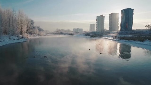 flying over the river in the winter in the city
