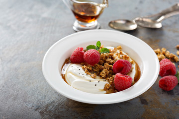 Yogurt bowl with raspberry and maple syrup