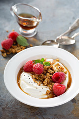 Yogurt bowl with raspberry and maple syrup
