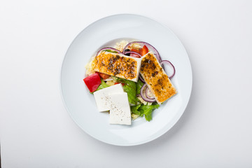 Fresh vegetable salad with grilled cheese on white background
