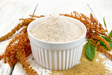 Flour amaranth in white bowl with grain on light board