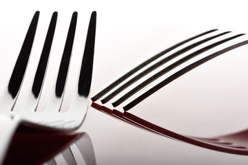 Concept with fork on red background III / The abstract concept of a simple subject