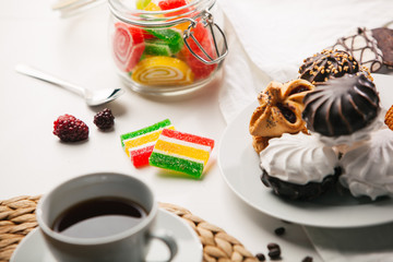 Cup of tea, cookies, a jar of jujube, and sweets on white