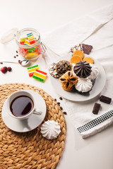 Cup of tea, cookies, a jar of jujube, and sweets on white