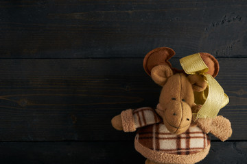 Soft toy moose on wooden texture  background. Copy space