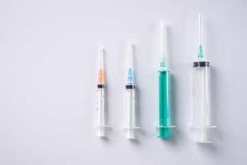 Syringes of different size on white background. Medicine plastic vaccination equipment
