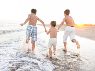 Fototapeta na wymiar Fun kids playing splash at beach