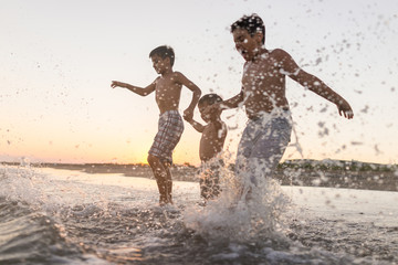 Fun kids playing splash at beach