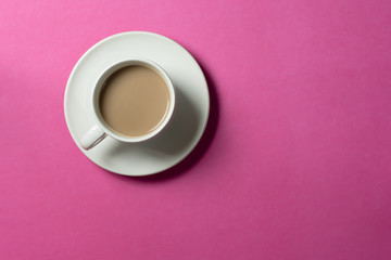 hot chocolate  in a ceramic cup on pink paper background