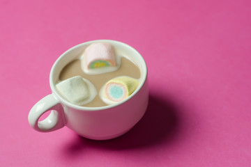 hot chocolate with marshmallows in a ceramic cup on pink paper b