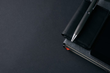 Close up of gentleman set. Magnifying glass, mobile phone, notebook, pen on dark background. Copy space