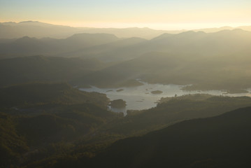Foggy sunrise over a mountain lake. Adam's peak, Sri Lanka