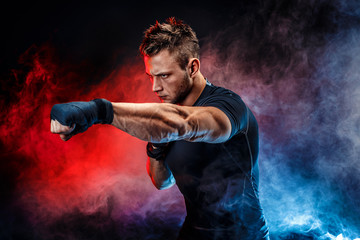 Studio portrait of fighting muscular man in smoke