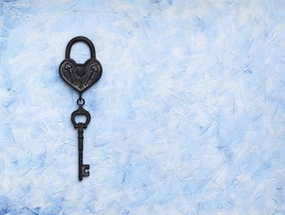iron key from the lock lying on wooden vintage background, top view