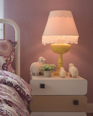 Cozy bedroom interior with pillows and reading lamp on bedside table